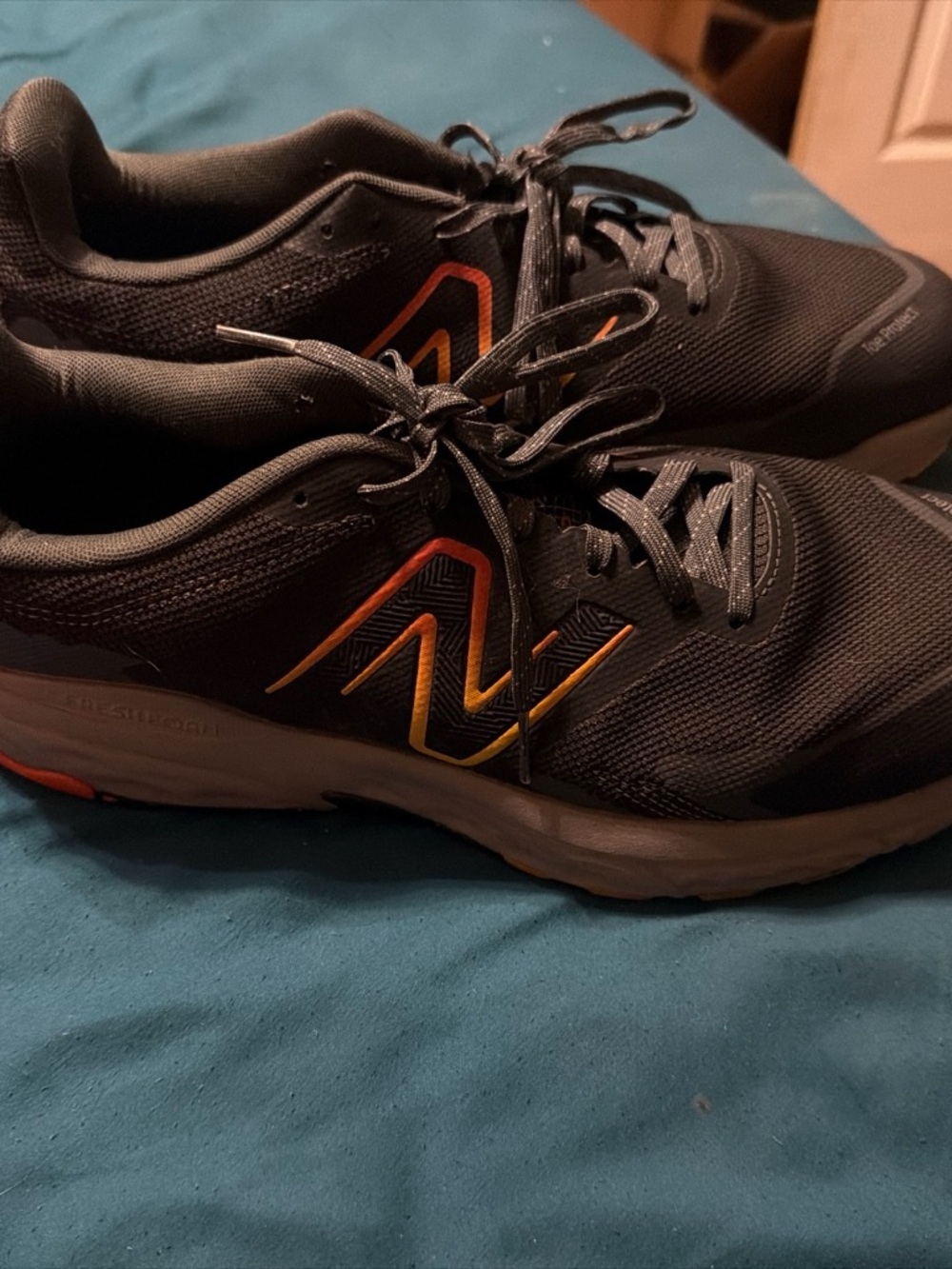 New Balance Men's Black Athletic Shoes with Orange Accent